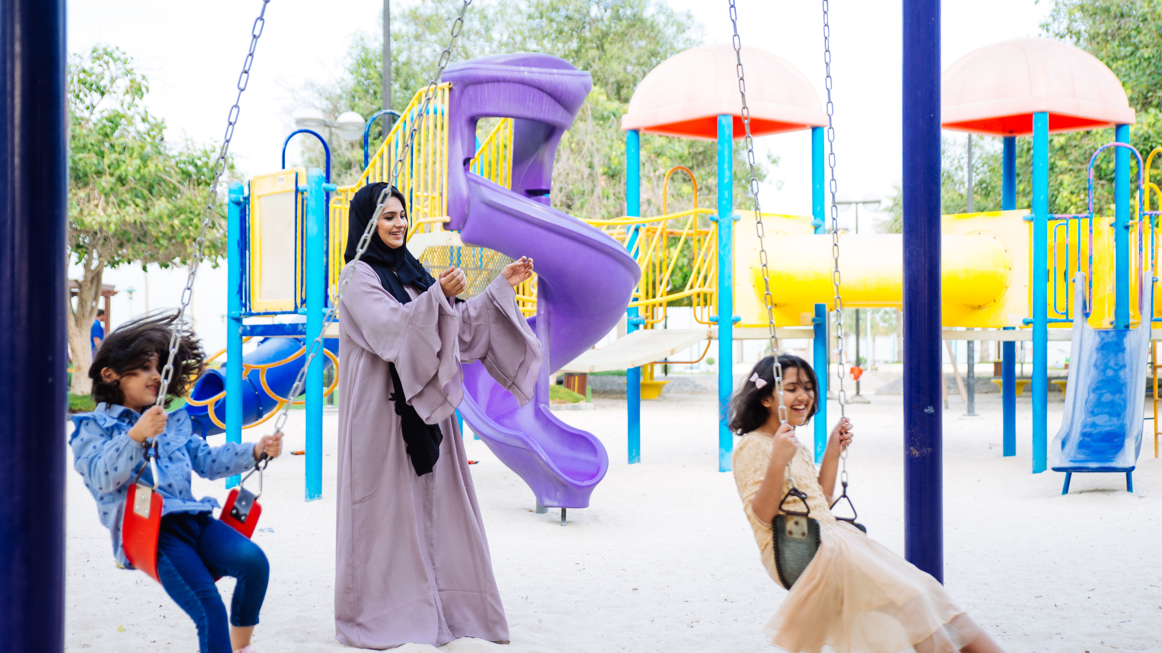 Mom and daughters spending time together at the park, in Dubai.