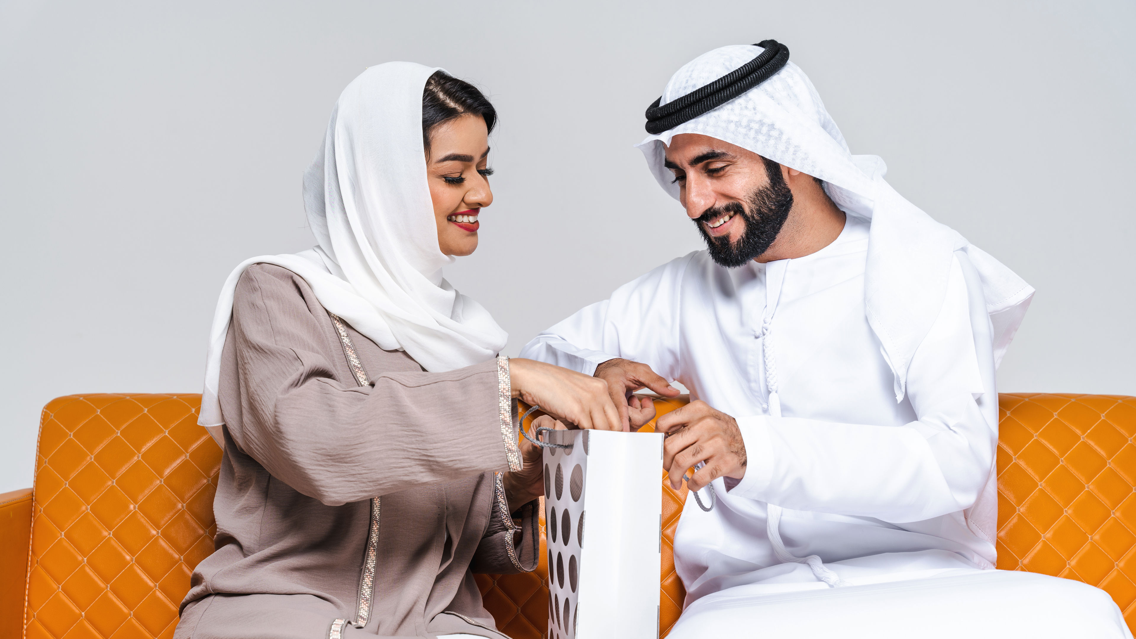 A couple is happily looking into a shopping bag together