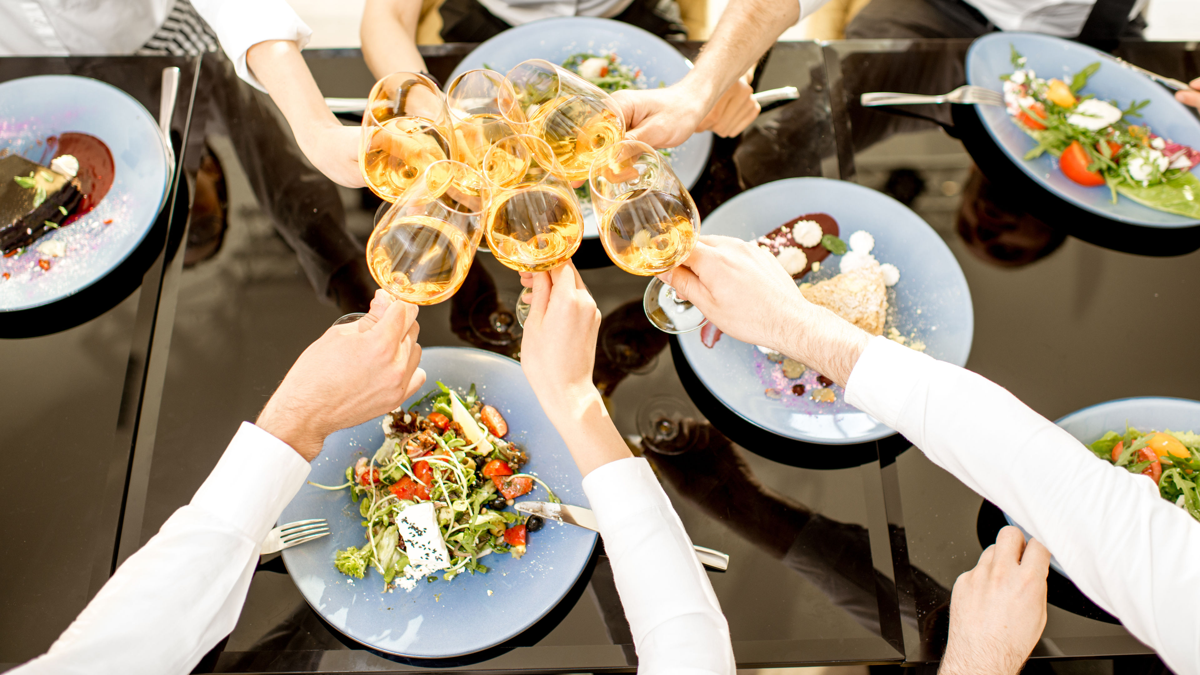 A group of people clinking wine glasses together