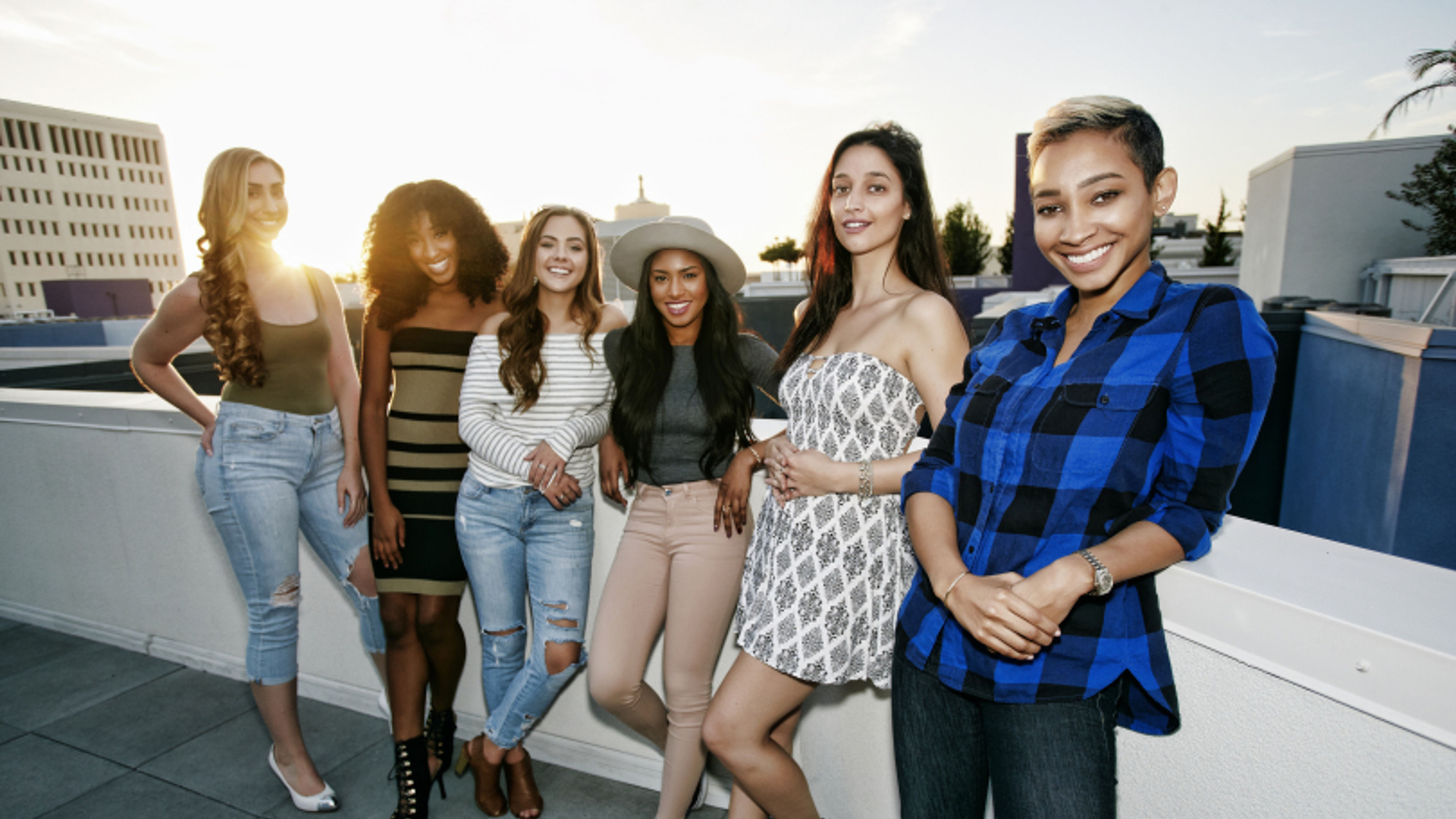 A group of young women partying on a city rooftop at dusk