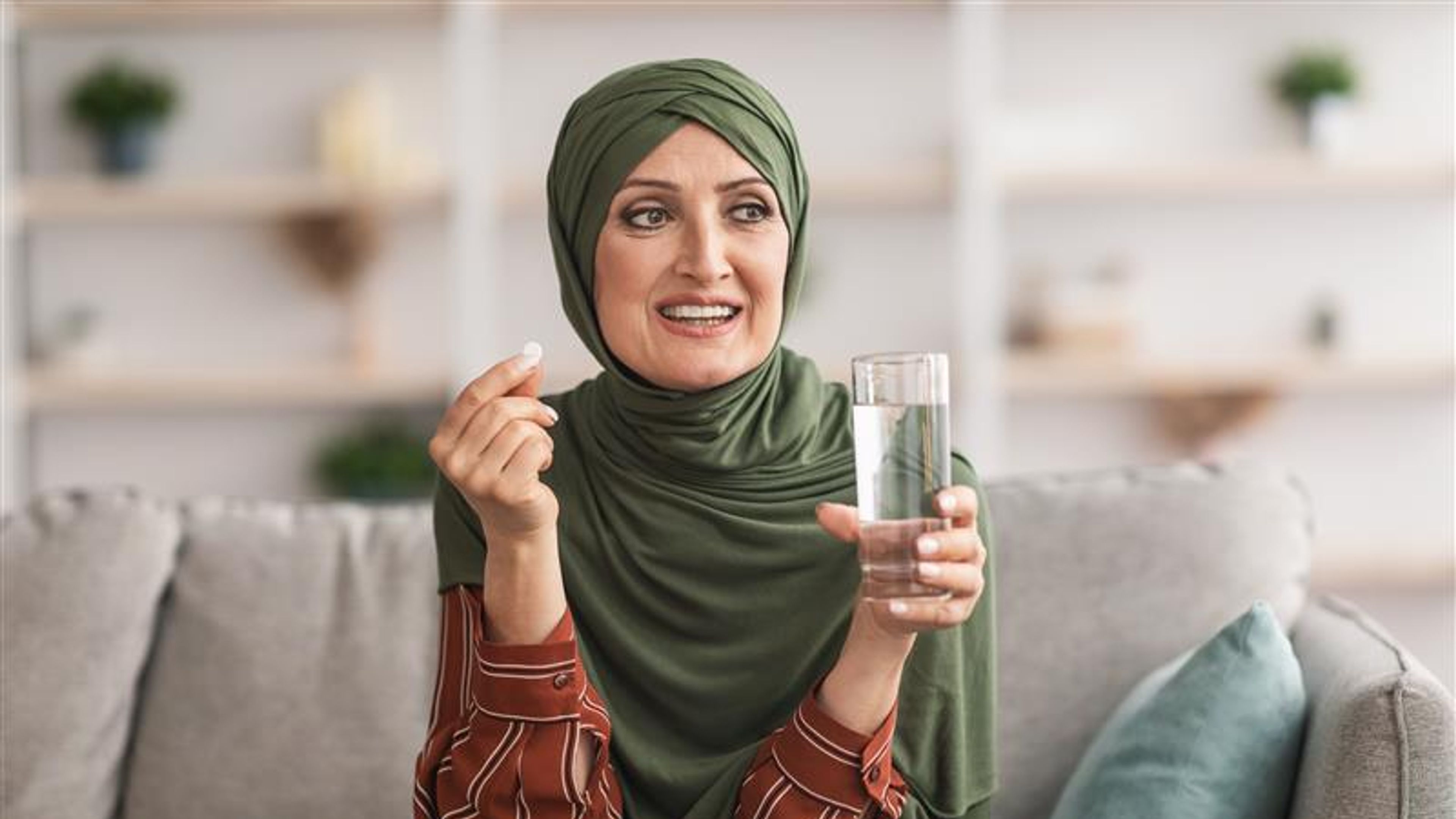 A woman is eating some pills