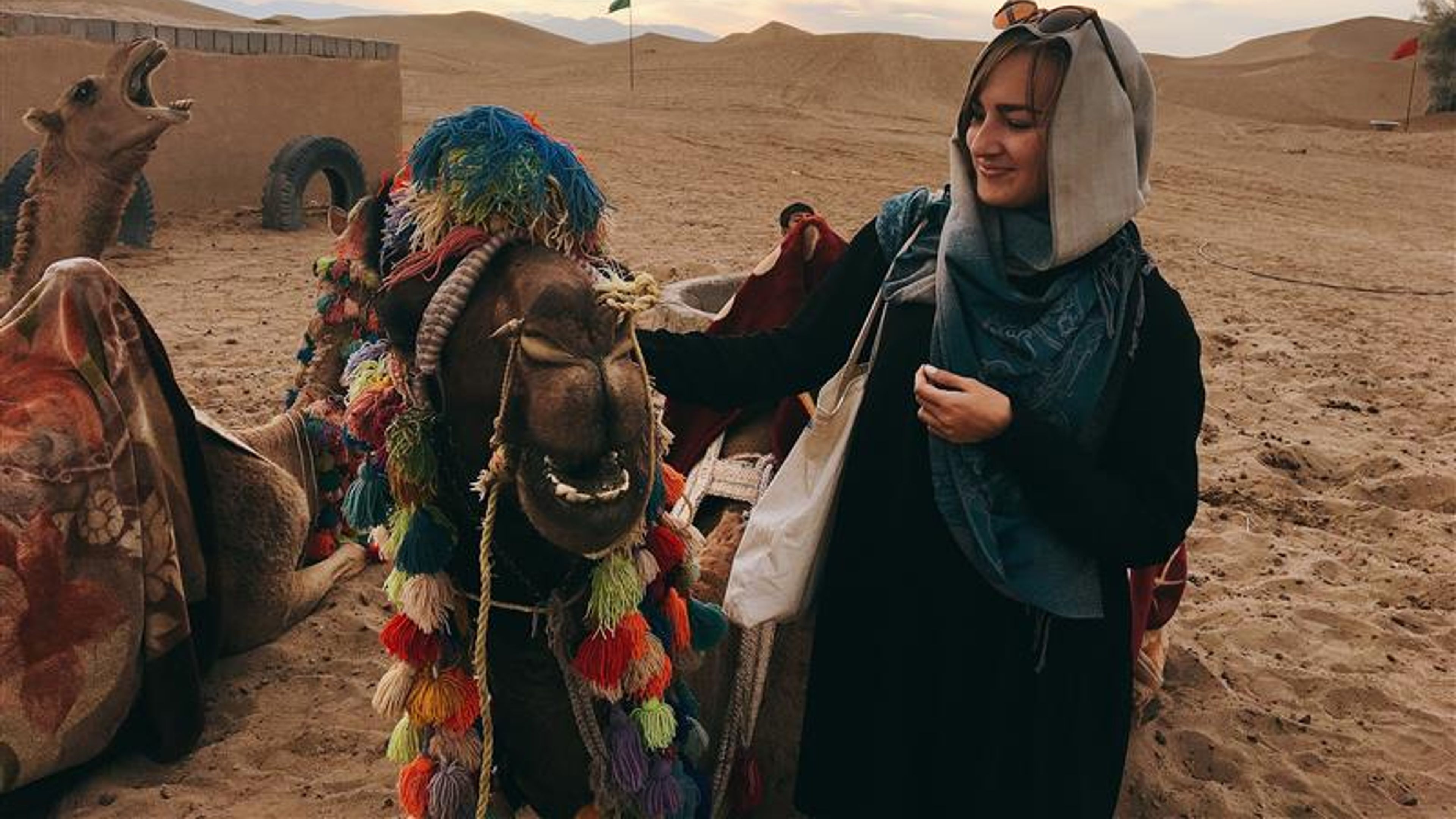A woman touching the camel