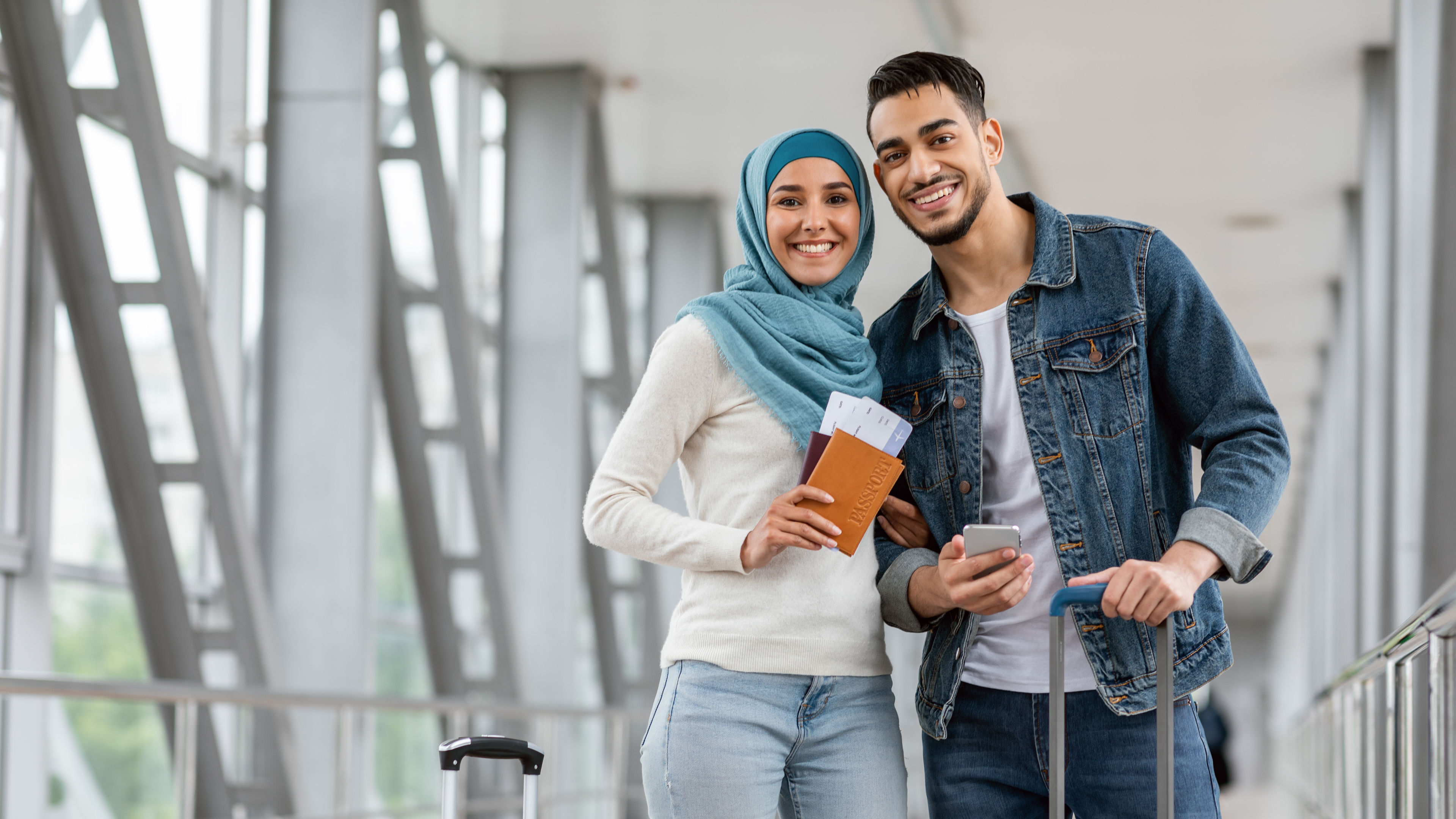 Happy Young Couple Standing At Airport.