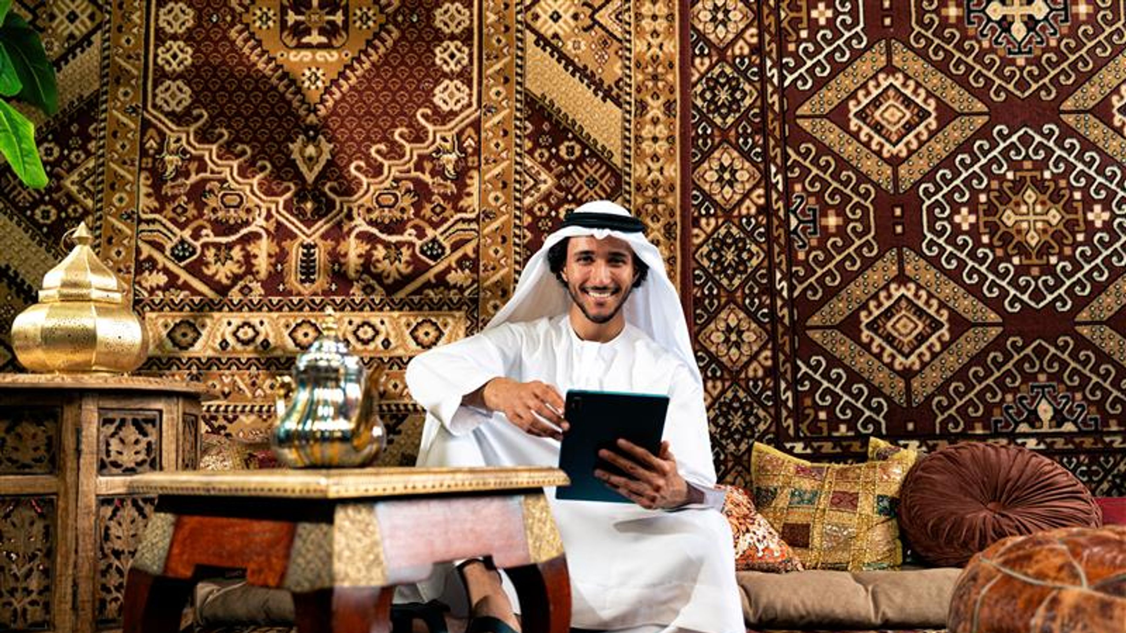 Man from emirati wearing kandura outfit Spending time in an arabian traditional house