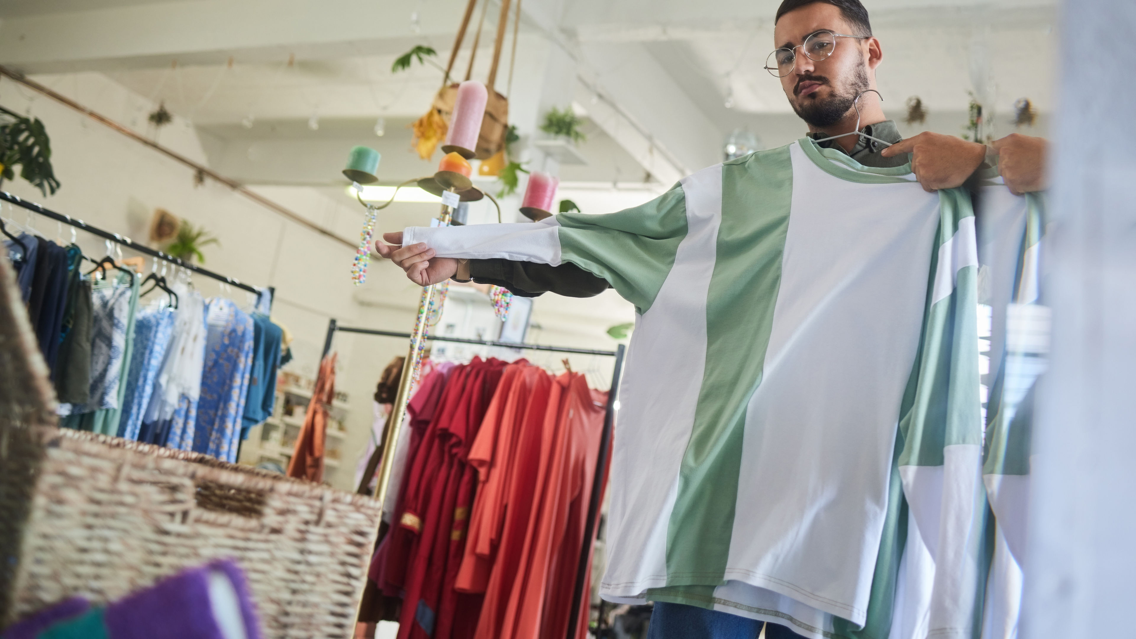 Man holding shirt in a clothing store