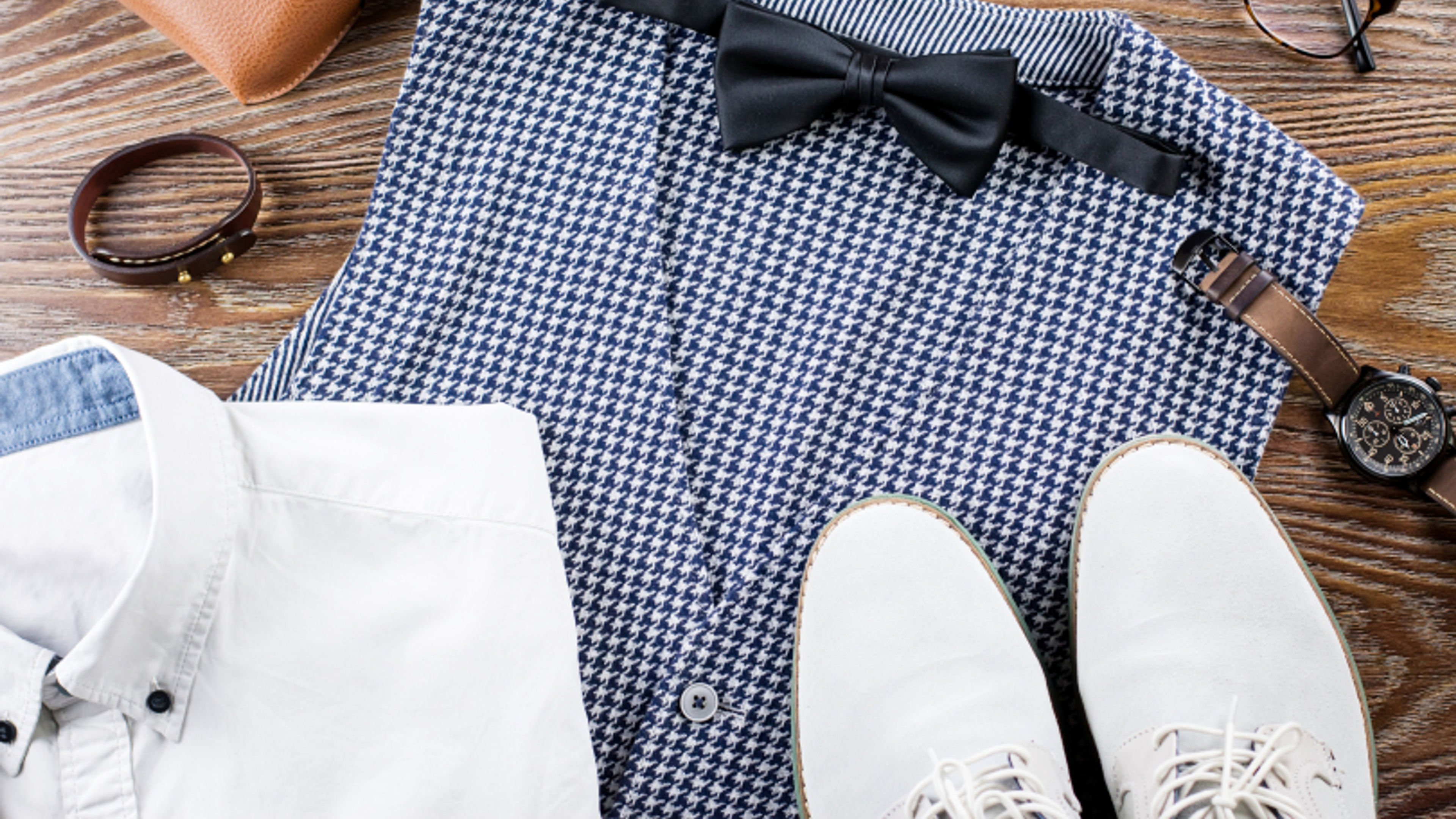 Men wearing stylish casual clothing and accessories on a wooden background 