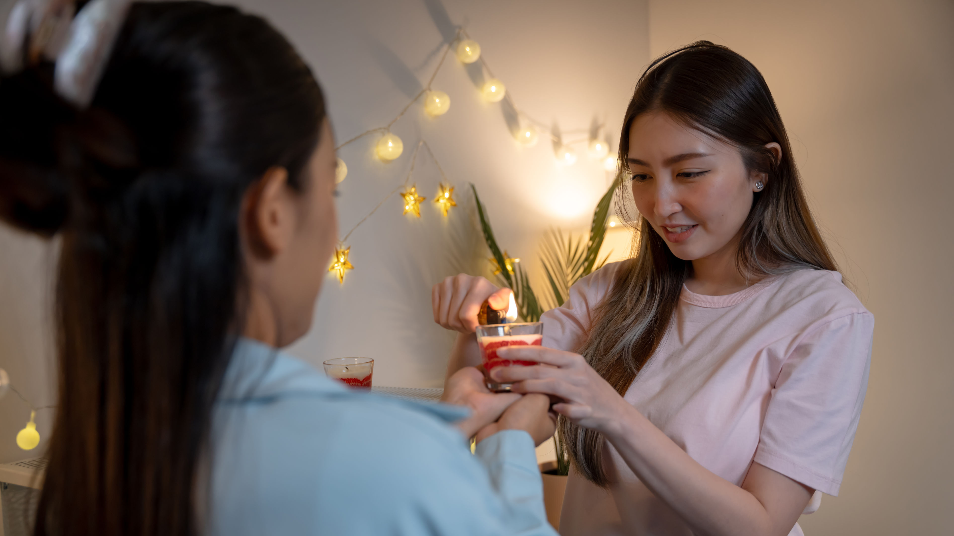 Two girls lighting up the candle