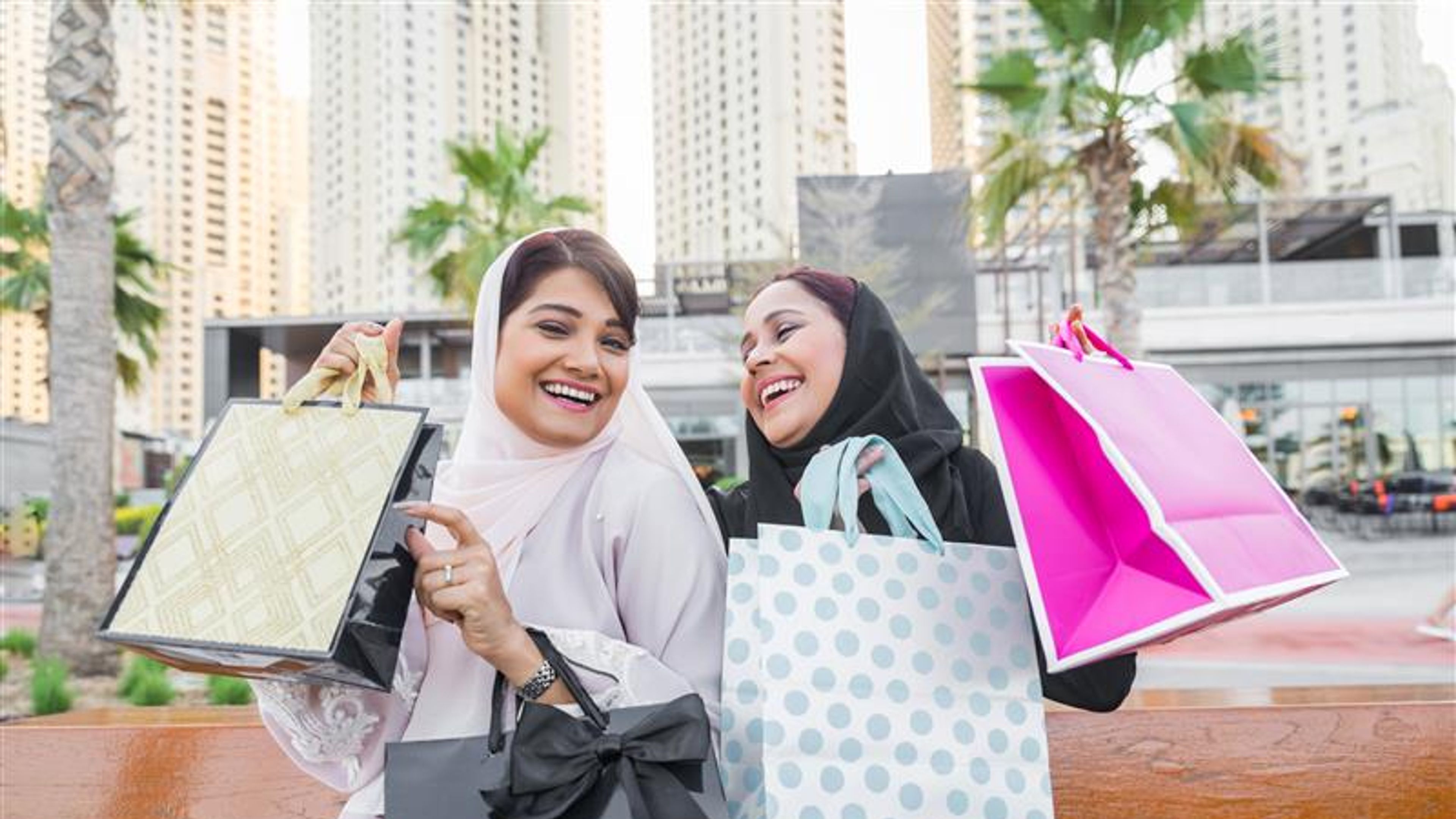 Two women happily leaving after shopping. 