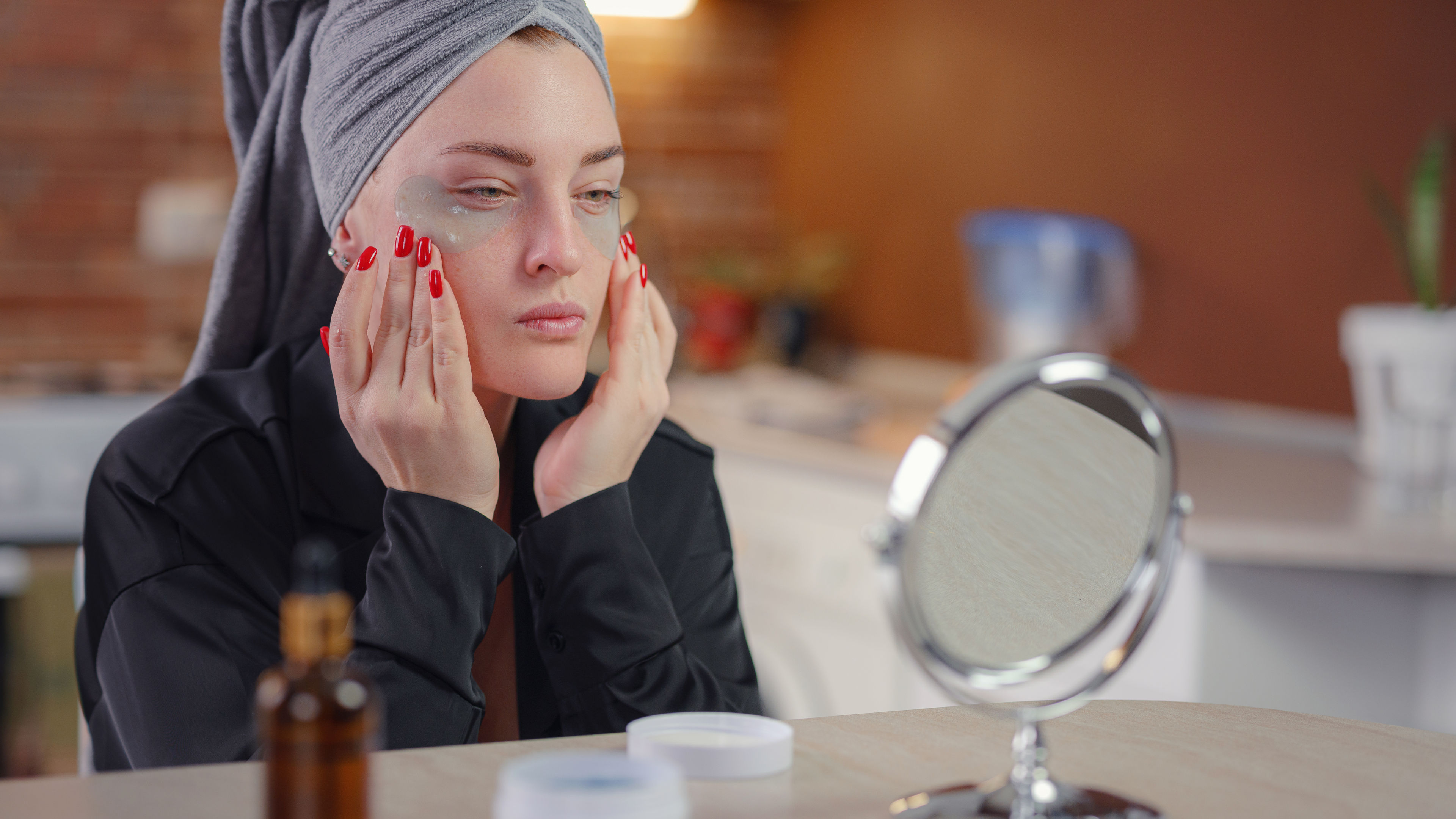 Woman placing patches under eyes