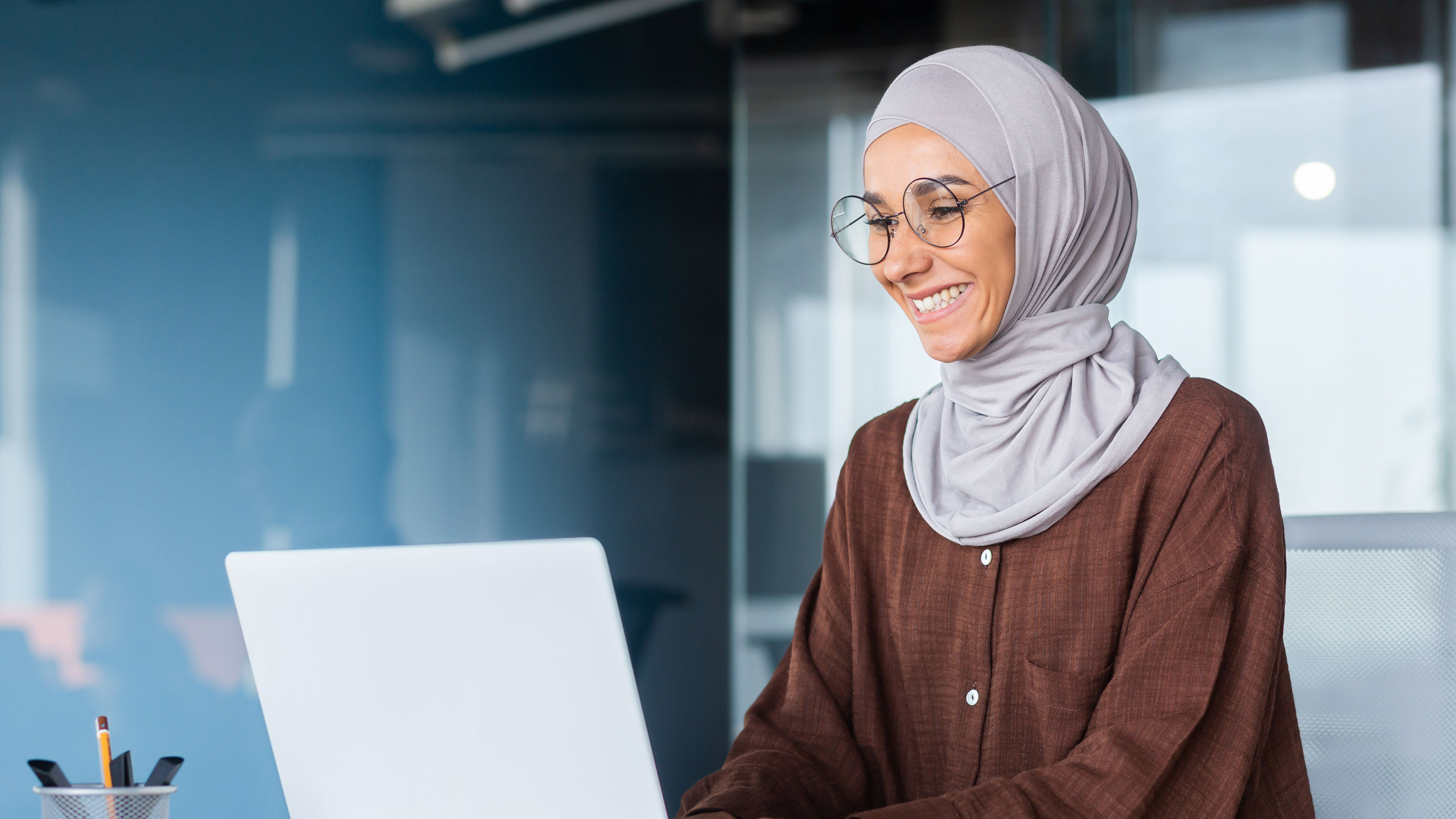  Young beautiful woman smiling and typing on laptop